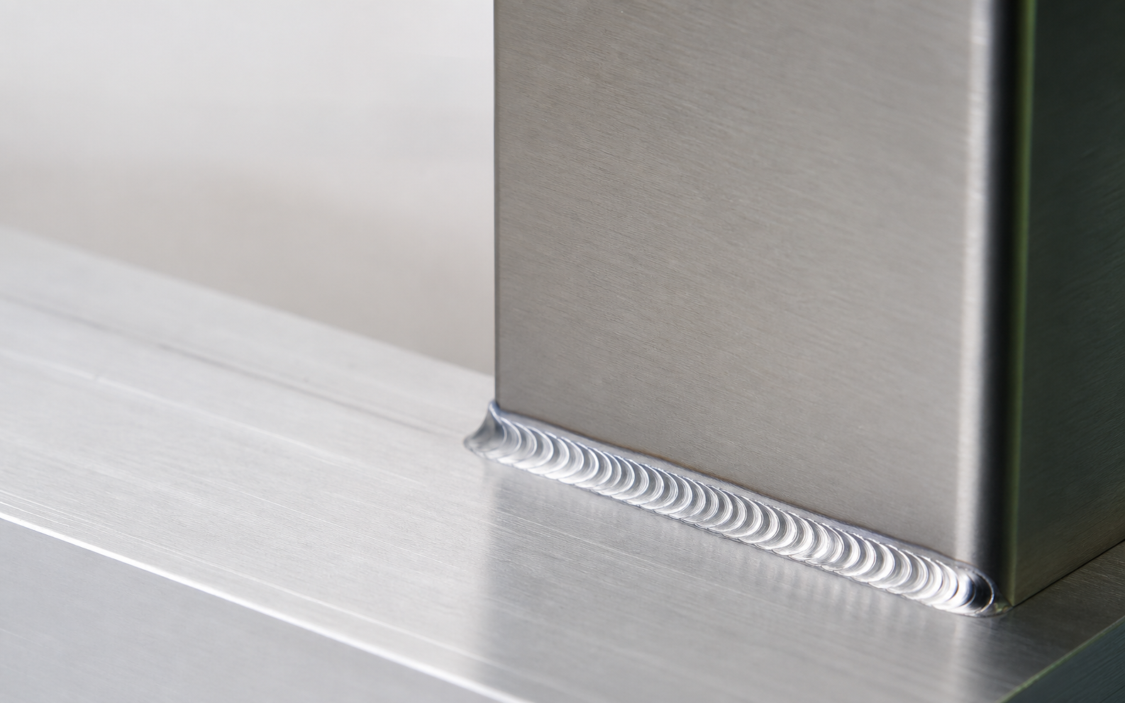Clean aluminum TIG weld detail in bright neutral light.