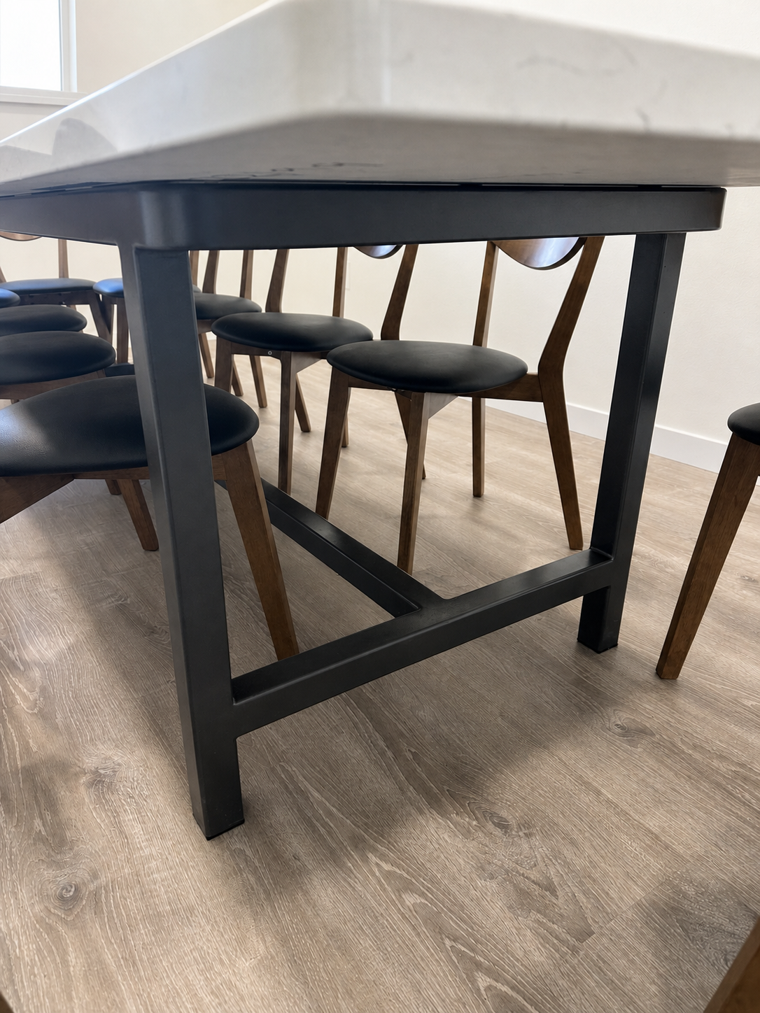 Close view of the black steel base supporting a custom dining table.