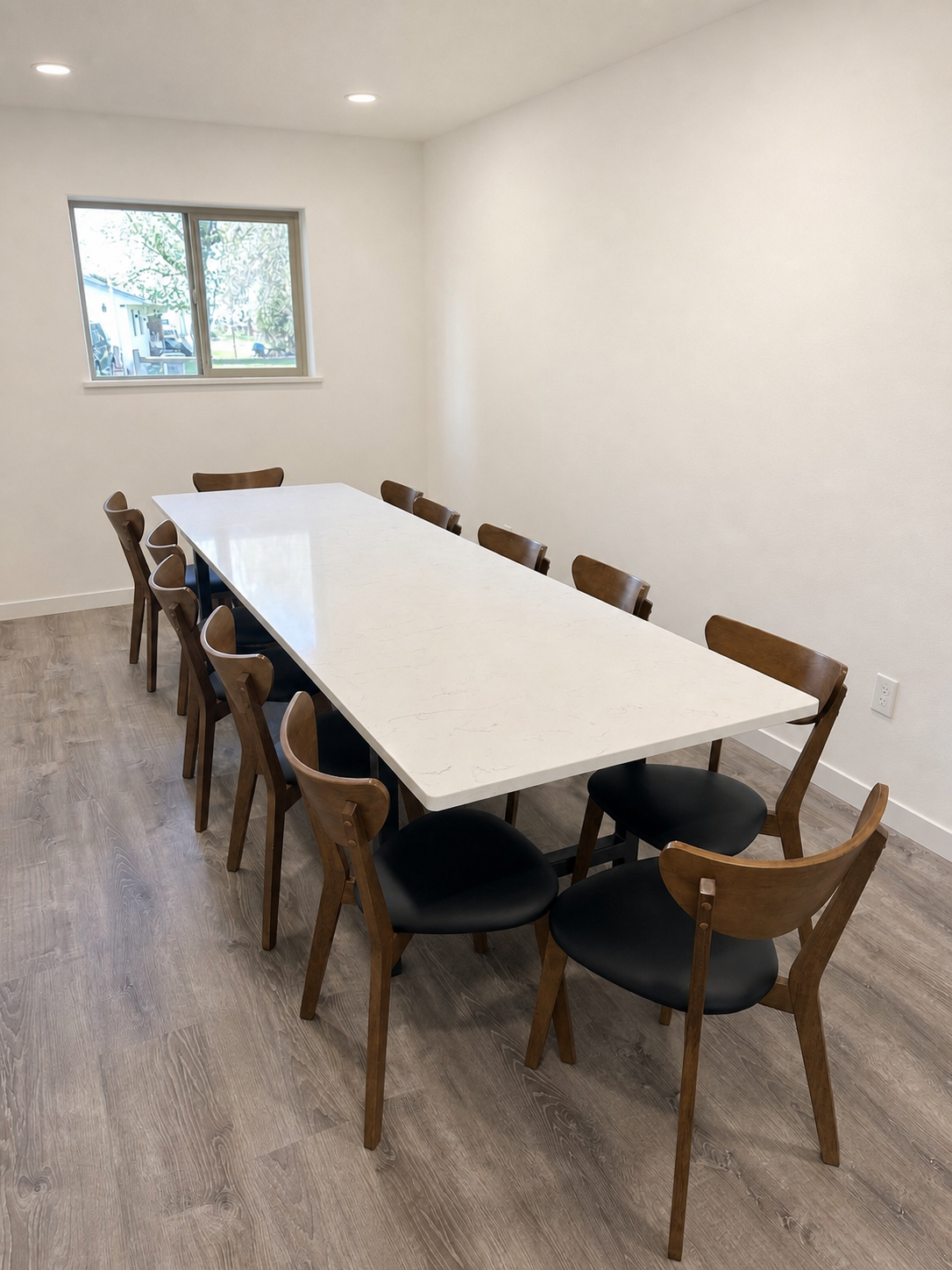 Finished custom dining table with a white top and black steel base.